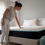 Mujer comprobando la comodidad del colchón en su habitación