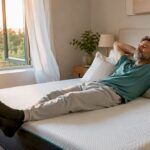 Un hombre disfruta de un merecido descanso sobre su colchón hecho a medida, relajándose en un dormitorio acogedor.