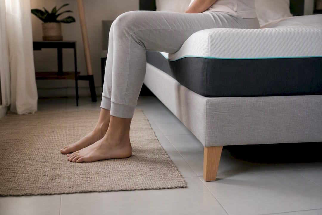 Persona comprobando la altura total de la cama al sentarse