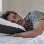 Persona durmiendo de lado apoyada en una almohada